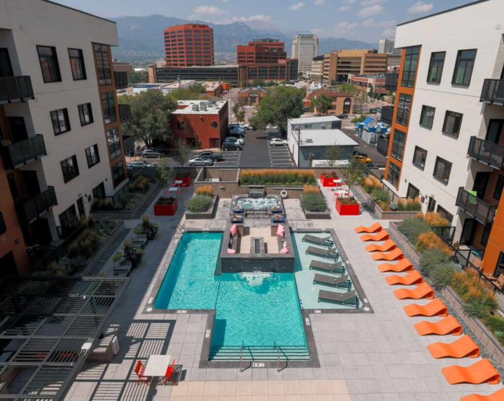 Patio view of a deluxe outdoor pool and hot tub in CO Springs